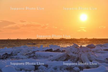 朝日とホタテ漁船と流氷