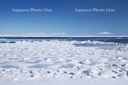 オホーツク海の流氷と知床連山と海別岳（右）