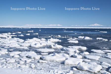 オホーツク海の流氷と知床連山と海別岳（右）