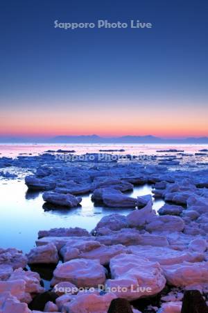 朝の流氷と知床連山