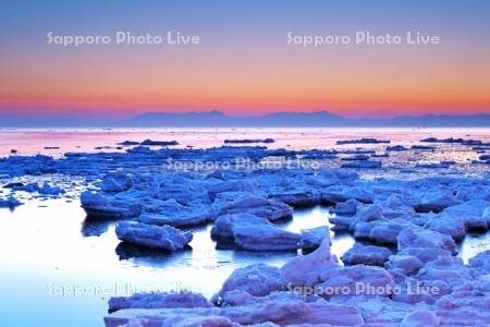 朝の流氷と知床連山
