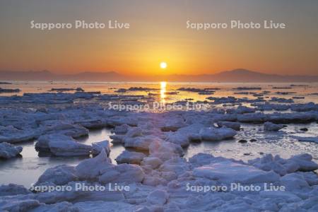 オホーツク海の日の出と流氷と知床連山（左）と海別岳（右）
