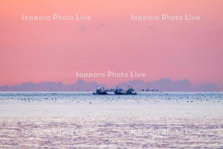 朝焼けと漁船