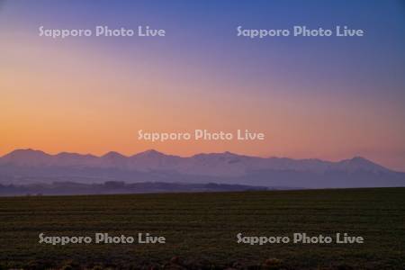 畑と十勝岳連峰の朝焼け