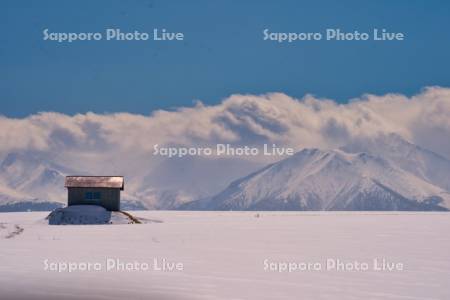 赤い屋根の小屋と十勝岳連峰