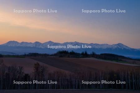 畑と十勝岳連峰の朝焼け